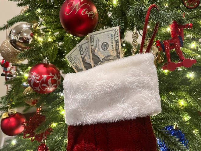 A stocking with 20 dollar bills hangs on a Christmas tree in this photo illustration taken on December 16, 2024. REUTERS/Lisa Shumaker/Illustration